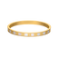 Gold-toned bangle bracelet with white iridescent Mother of Pearl inlay and gold-toned Escada monograms.