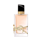 Rectangular clear glass perfume bottle with pale liquid, gold-toned YSL logo, textured gold collar, and an angled black cap.