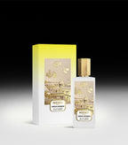 Frosted white rectangular perfume bottle with gold-toned cap and label showing Parisian rooftops and rosebuds. Matching yello