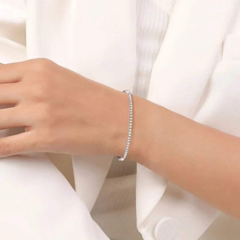 Silver-toned tennis bracelet featuring a single row of small, round, clear stones.