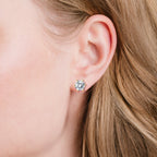One round clear stud earring with a gold-toned six-prong setting.