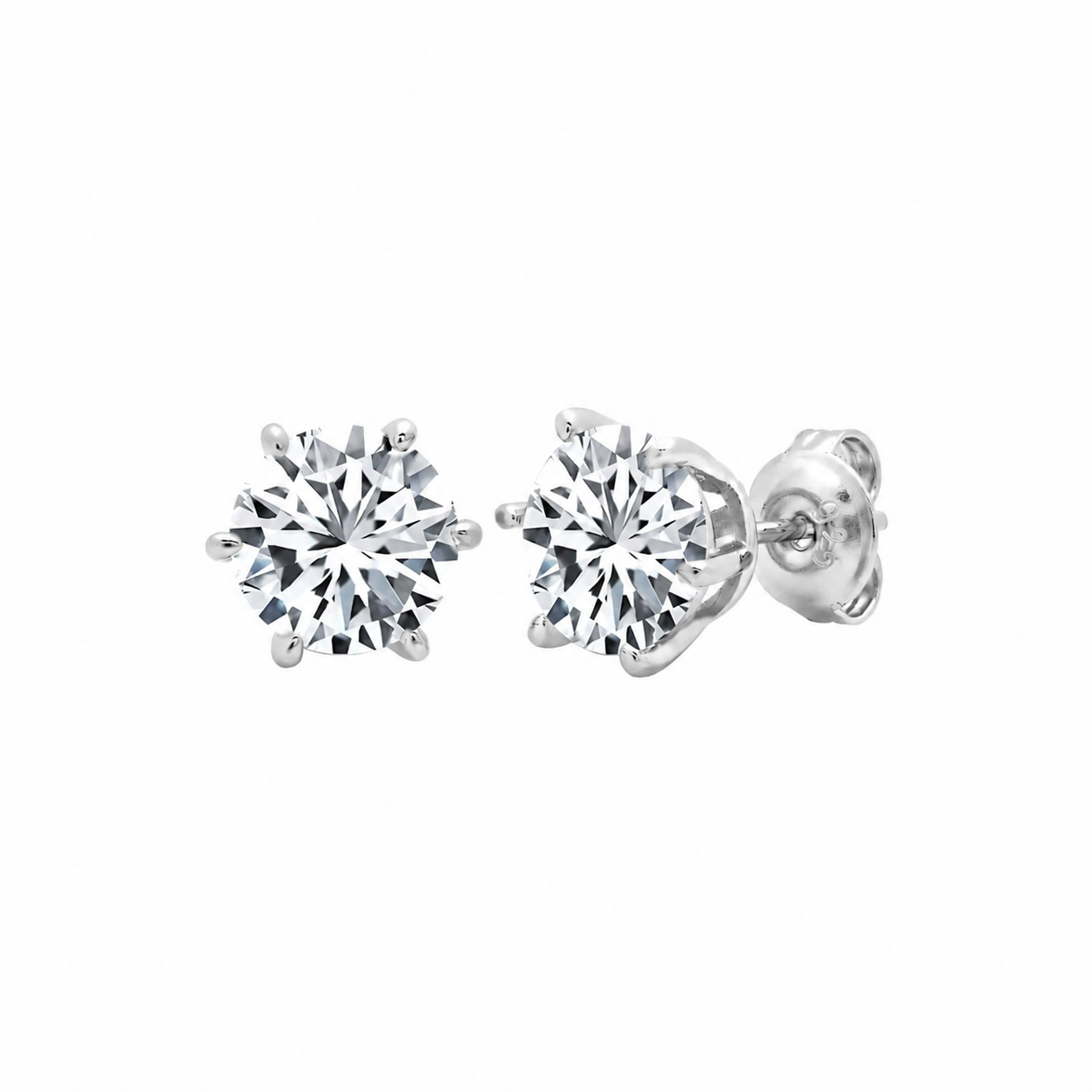Pair of silver-toned stud earrings, each with a round, clear faceted stone held by a six-prong setting. One earring shows its