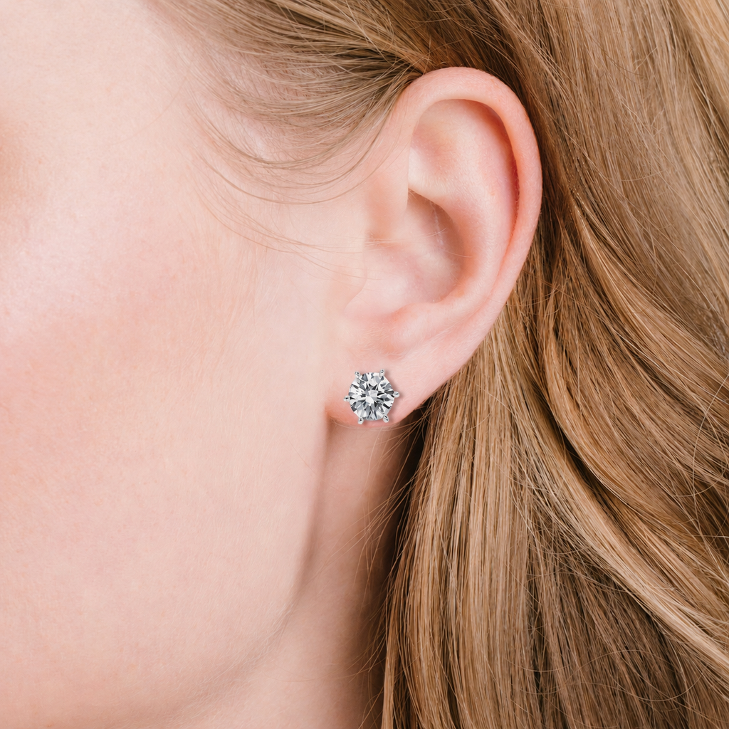 Round, clear, faceted stone stud earring with a silver-toned six-prong setting.