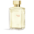 Clear faceted glass perfume bottle with pale yellow liquid, a gold-toned rectangular cap, and gold-toned and reddish-orange t