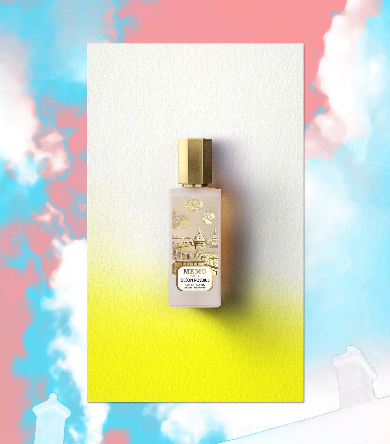 Frosted glass perfume bottle with light pink liquid, gold-toned hexagonal cap. Label has gold-toned rosebuds and a cityscape.