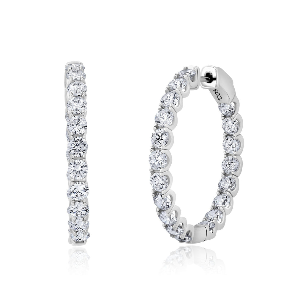 Pair of large round hoop earrings in silver-toned metal, each adorned with clear brilliant-cut stones.