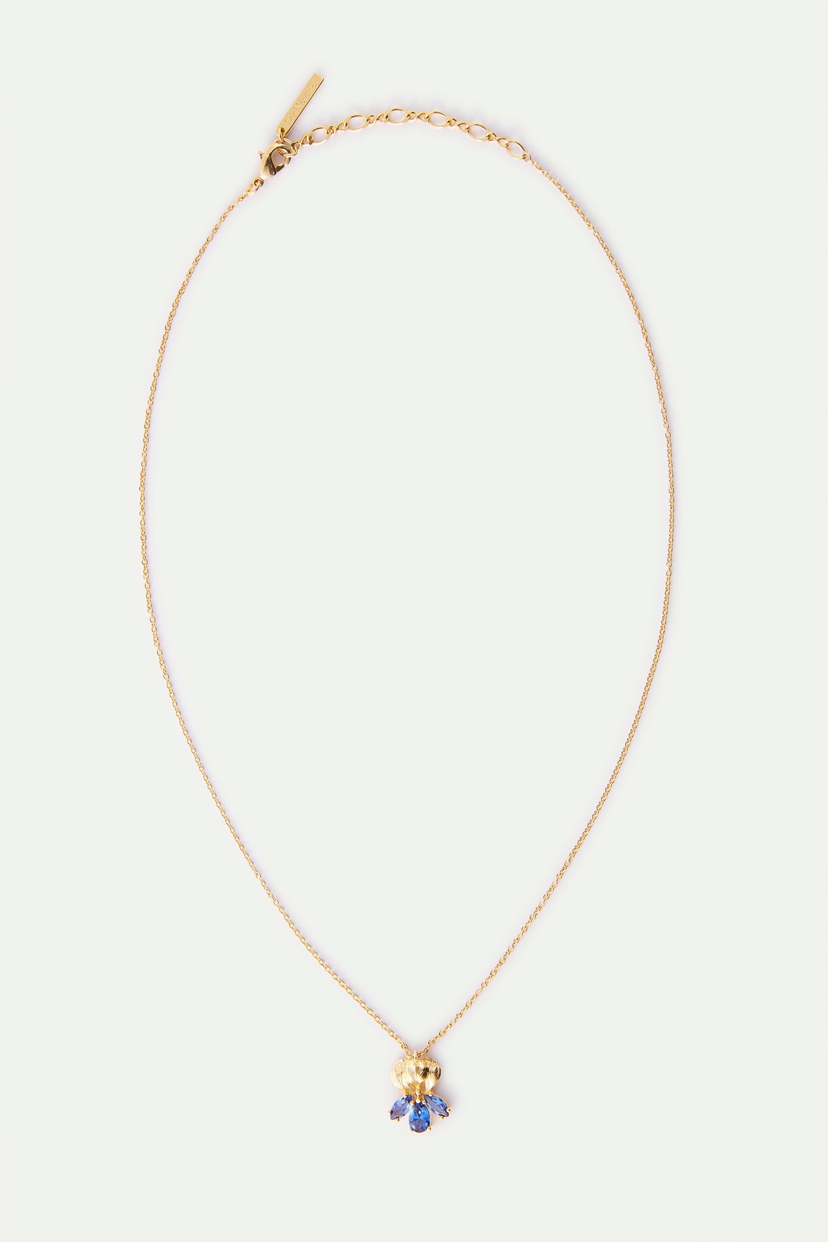 Delicate gold-toned necklace with a textured gold-toned pendant featuring a cluster of blue marquise-shaped stones.