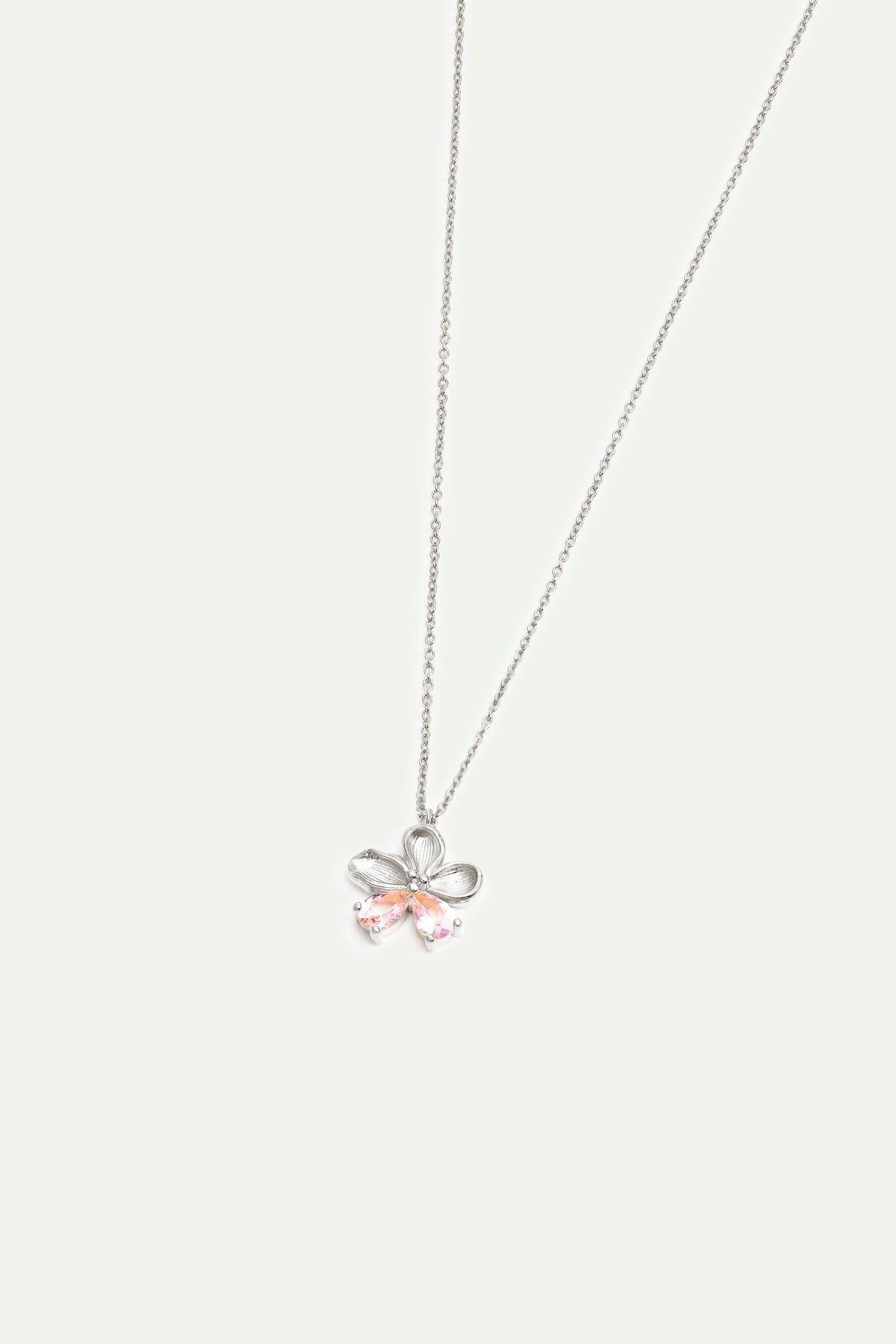 Silver-toned necklace with a flower-shaped pendant. The pendant has looped petals and two light pink teardrop-shaped stones.