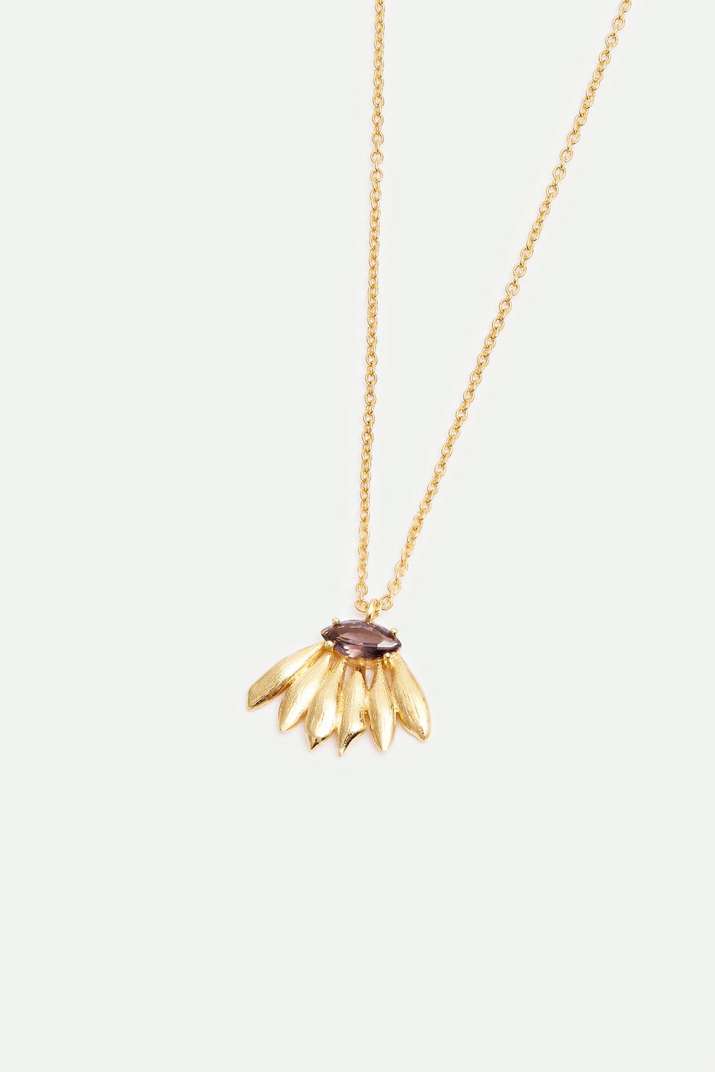 Gold-toned necklace with a dark purple marquise gemstone above a fan of six textured gold-toned leaf-shaped elements.