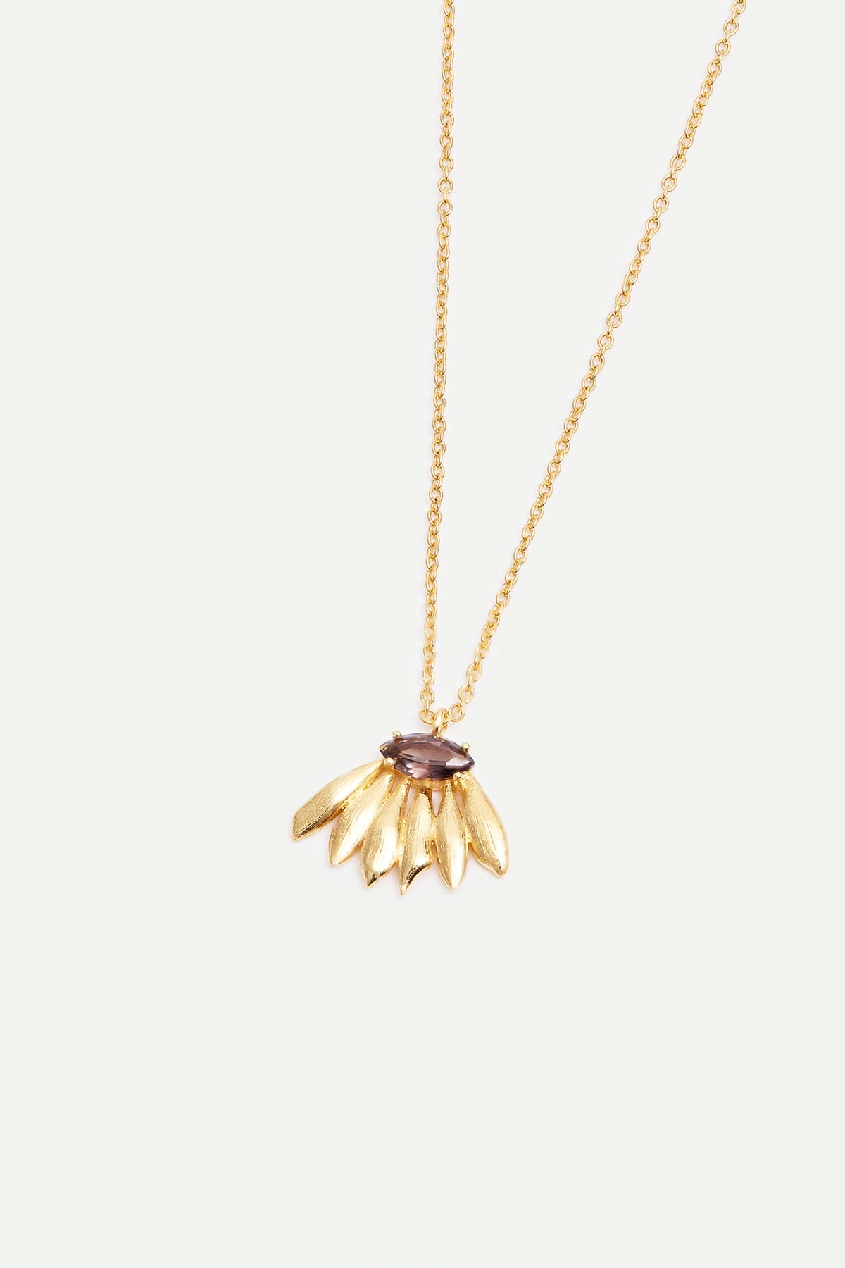 Gold-toned necklace with a dark purple marquise gemstone above a fan of six textured gold-toned leaf-shaped elements.