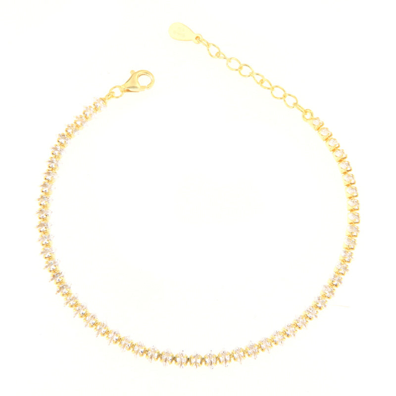 Gold-toned tennis bracelet with a continuous line of clear, faceted stones, a lobster clasp, and an adjustable chain extender