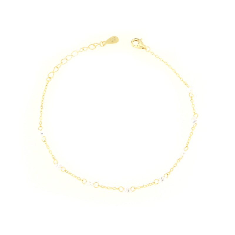 Gold-toned delicate chain bracelet with clear faceted zircon embellishments, a lobster clasp, and an extender chain.