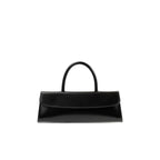 Front view of the BY FAR Mini Longa top handle bag in black semi-patent leather featuring an elongated rectangular silhouette and a single curved handle against a light grey background.