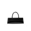 Front view of the BY FAR Mini Longa top handle bag in black semi-patent leather featuring an elongated rectangular silhouette and a single curved handle against a light grey background.