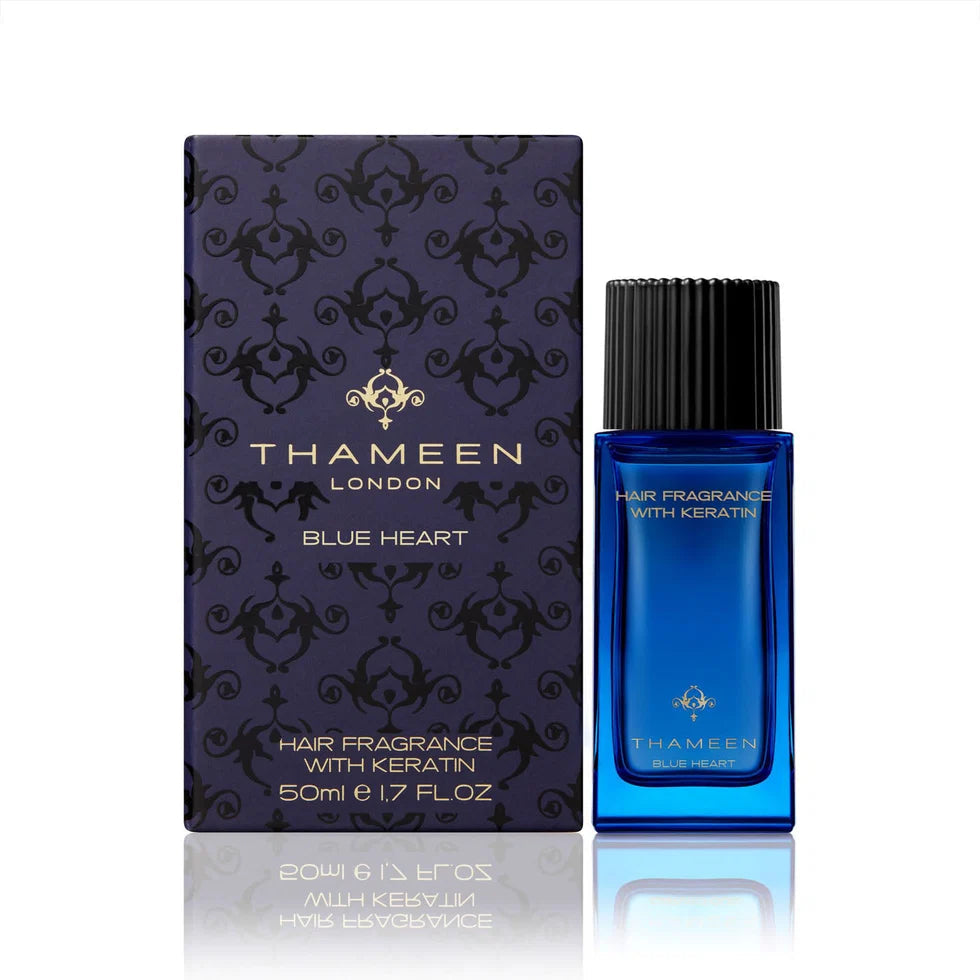 Blue rectangular glass bottle of Thameen hair fragrance with black ribbed cap, next to its dark blue patterned box.