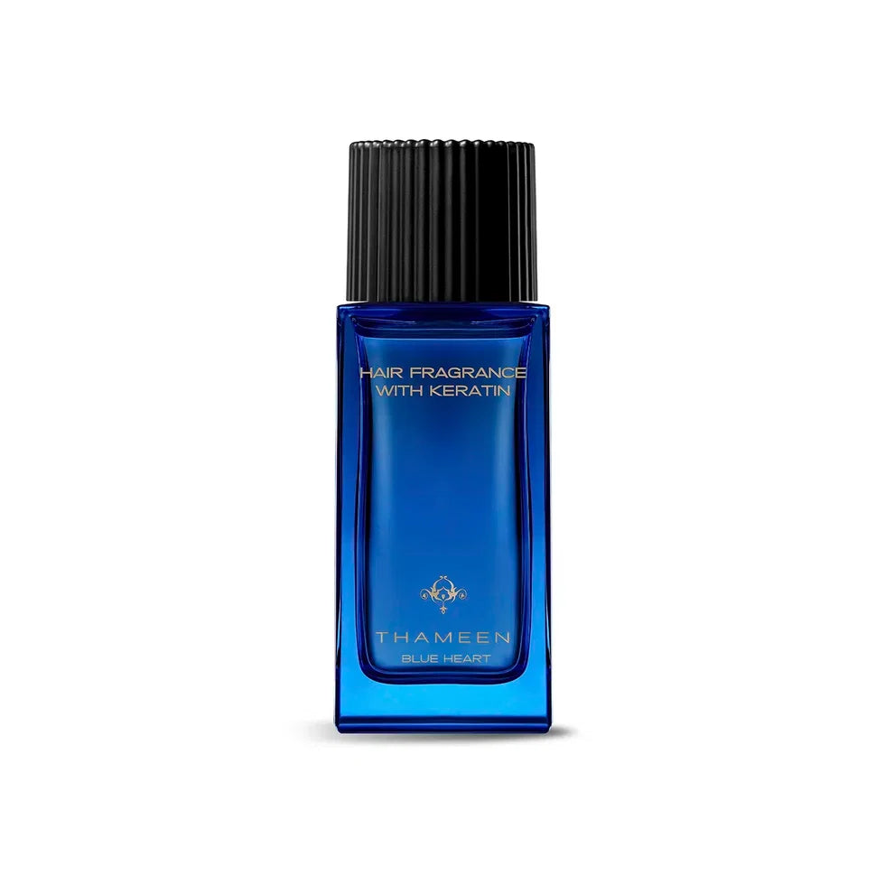 Blue rectangular glass bottle of hair fragrance with a black ridged cap and gold-toned emblem. Text reads "HAIR FRAGRANCE WIT