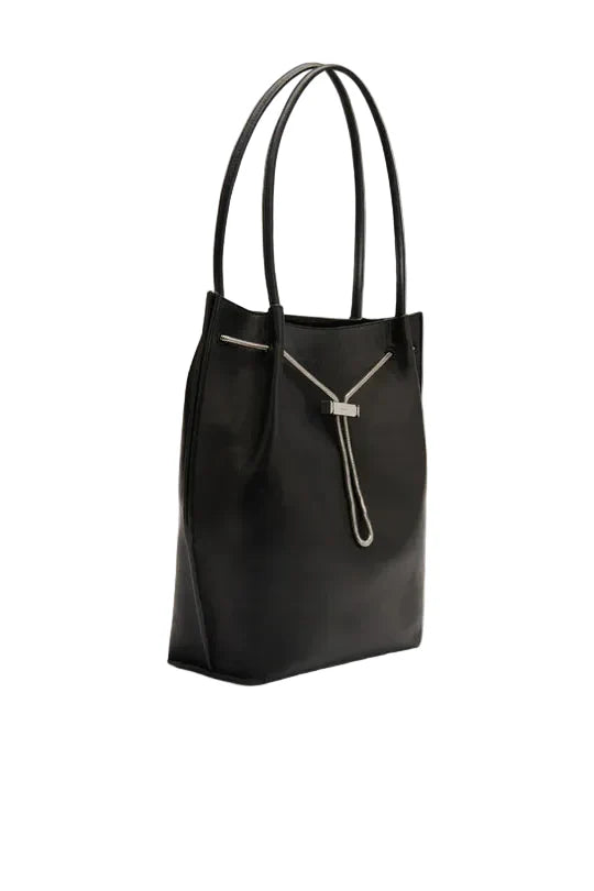 Side view of the BY FAR Kayla shoulder bag in black lambskin leather featuring a slouchy hobo silhouette, dual tubular straps, and a silver-tone chain toggle closure against a neutral background.