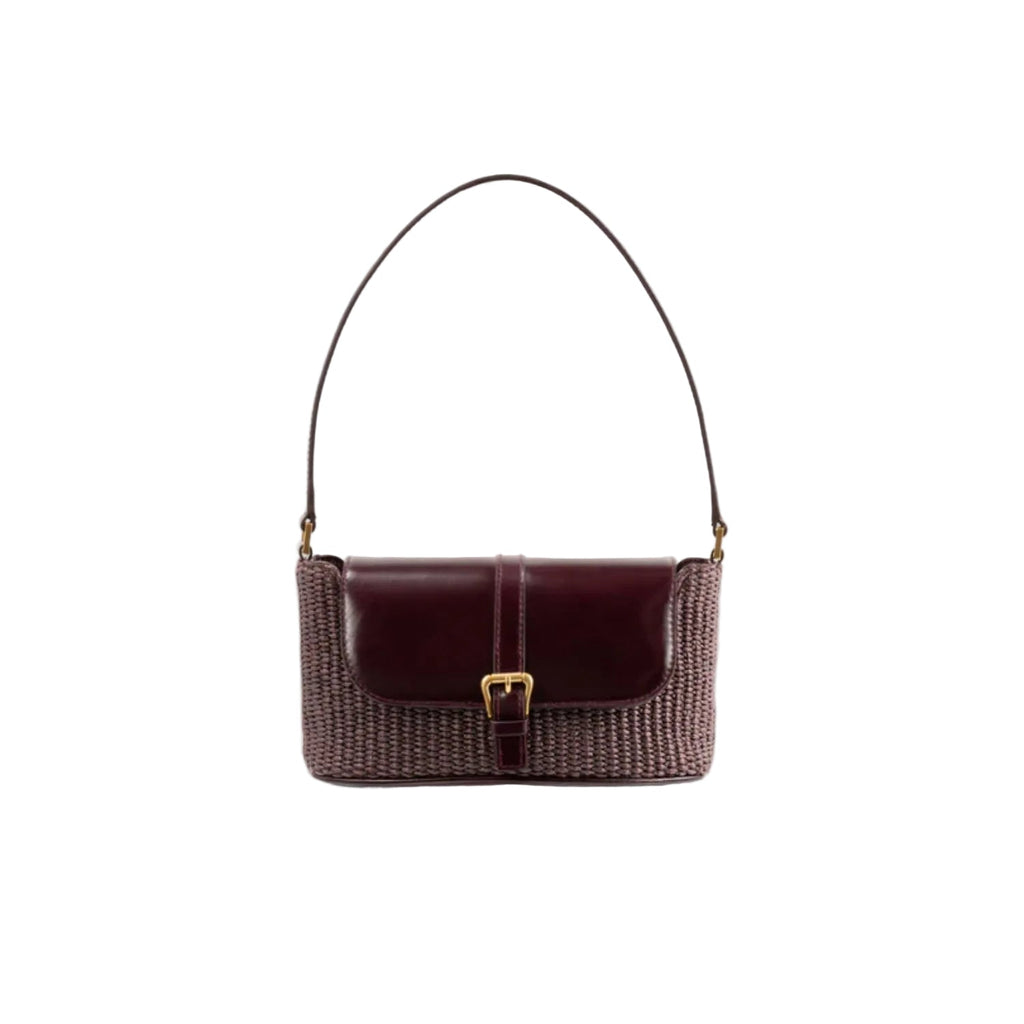 Front view of the BY FAR Miranda baguette bag featuring a purple grape-colored woven raffia body, a smooth dark leather front flap, and a gold buckle against a grey background.