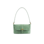 Front view of the BY FAR Miranda baguette bag in a light green croco-embossed leather featuring a matching shoulder strap and gold-tone buckle against a light grey background.