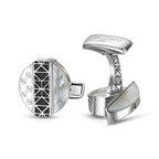 Silver-toned cufflinks. One has a round face with mother-of-pearl, black geometric inlay, and 'S' monogram. The other shows a