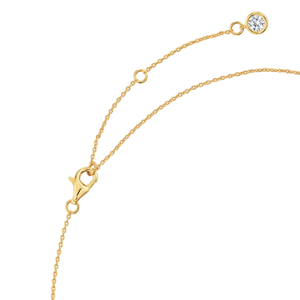Gold-toned necklace with a lobster clasp, an extender chain, and a small round clear stone in a bezel setting at the end.