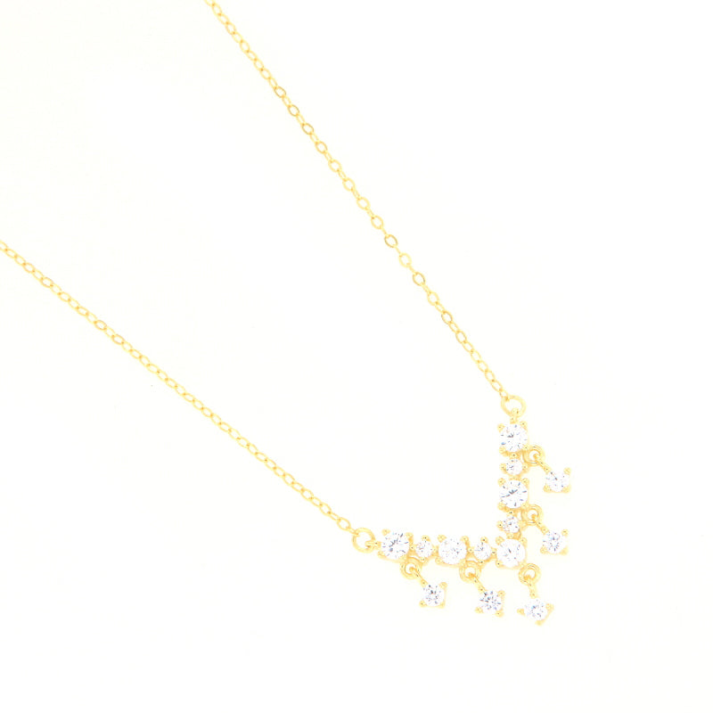 Gold-toned necklace with a delicate chain and a V-shaped cluster of clear faceted stones.