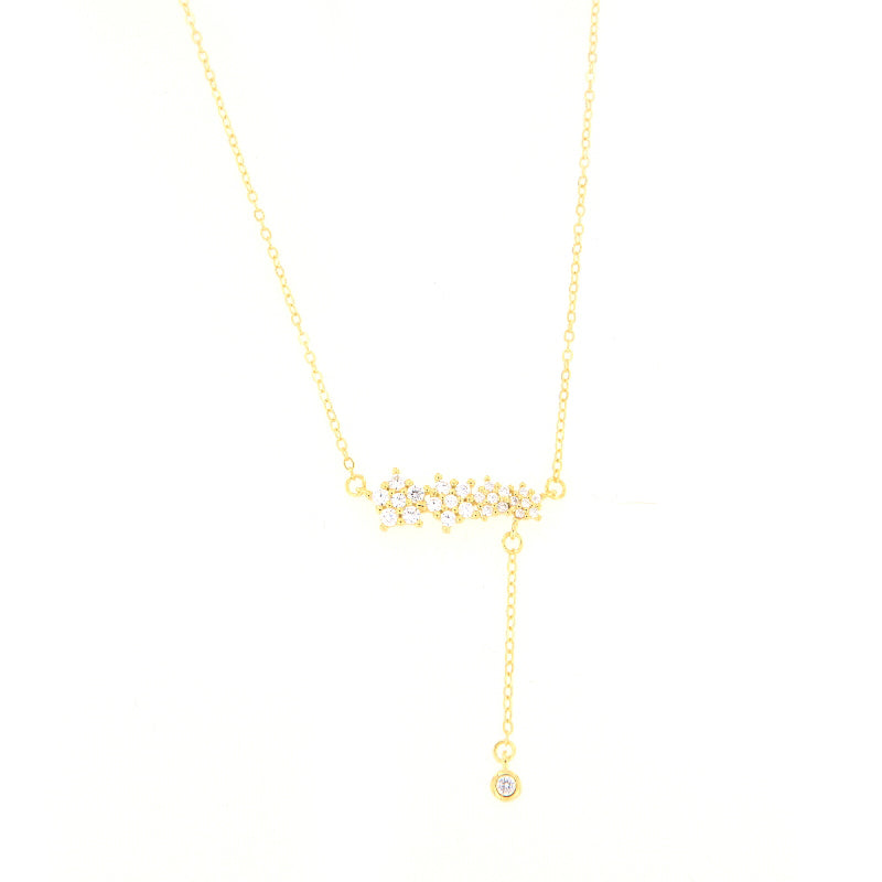 Gold-toned delicate chain necklace with a central cluster of clear star-shaped faceted stones and a drop chain with a single