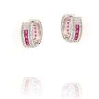 Pair of silver-toned hoop earrings with a central row of square pink stones, flanked by clear paved stones. Inner hoop has pi