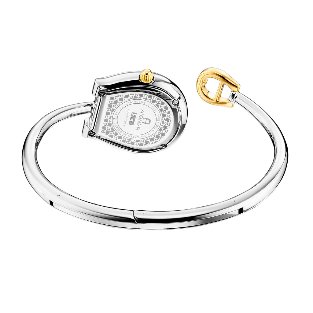 An angled rear view of the Aigner Flora S timepiece showcasing the engraved stainless steel horseshoe case back detailed with technical specs, the textured background engraving, the fluted yellow gold crown, and the open torque bypass bangle structure.