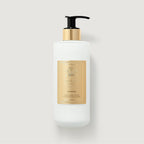 Frosted white glass bottle of Creed Aventus Hand & Body Lotion with a black pump and gold-toned collar and label.