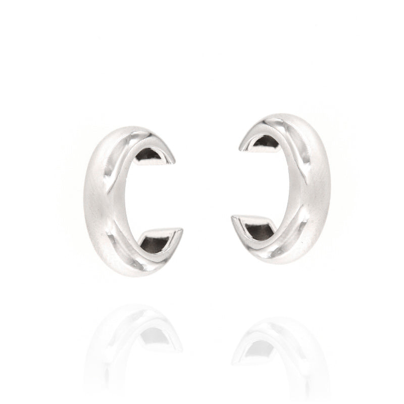 Pair of silver-toned metallic C-shaped ear cuffs with a polished finish and subtle raised ridge detail.
