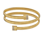 A frontal studio perspective shot of the Saint Honoré Tubogas multi-layered gold-plated wrap bangle against a white background, highlighting the engraved logo end caps set with rows of clear crystals.