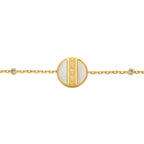 Gold-toned chain bracelet with a circular mother-of-pearl charm and a gold-toned Greek key pattern. Small clear crystals on t
