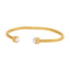 Gold-toned twisted open-cuff bangle with white faux pearls, clear crystals, and a Greek key pattern on the end caps.
