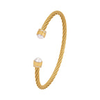 Gold-toned twisted bangle with two white pearls, each end featuring a gold-toned cap with clear crystals and a Greek key patt