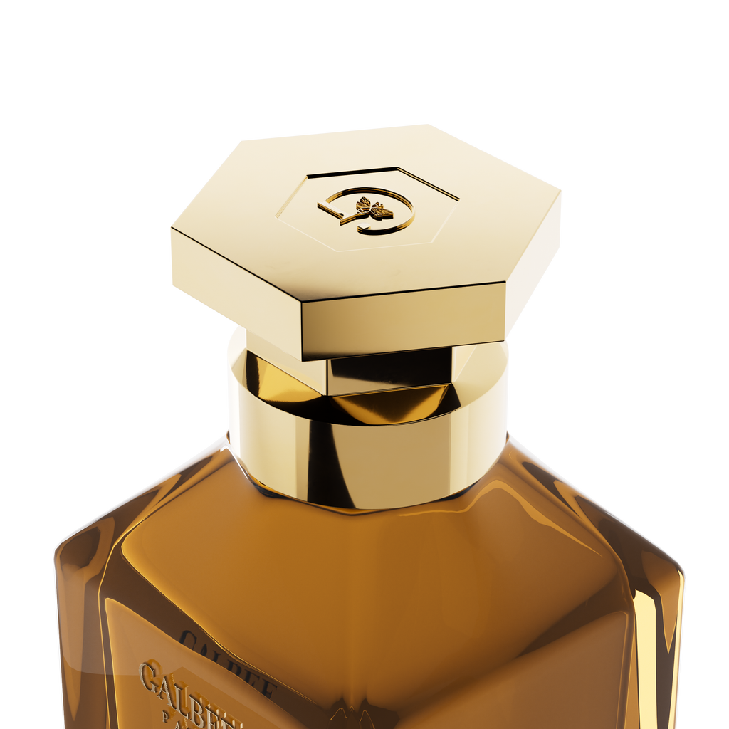 A close-up detail shot of the golden hexagonal cap on the Galbee Paris bottle, showcasing the delicate bee engraving on the top surface.
