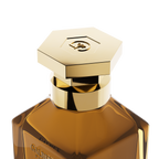 A close-up detail shot of the golden hexagonal cap on the Galbee Paris bottle, showcasing the delicate bee engraving on the top surface.