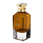 A three-quarter perspective view of the Galbee Paris Galbee Is Woody perfume bottle, showing its clear glass base, amber interior, and hexagonal gold cap.