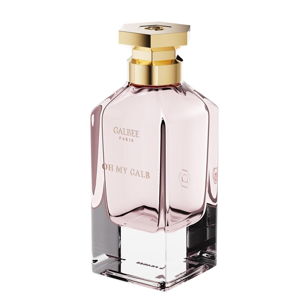 A three-quarter perspective view of the Oh My Galb perfume bottle, showing its clear glass base, soft pink interior, and hexagonal gold cap.