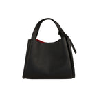 Black pebbled leather tote bag with a single top handle tied in a knot on the right side, and a red interior lining.