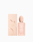 Light peach perfume bottle with a gold-toned neck and oval cap, featuring raised abstract shapes. Matching rectangular box wi