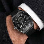 Black tonneau watch with textured black dial, silver-toned markers, sub-dial, date, bezel screws, and black leather strap.