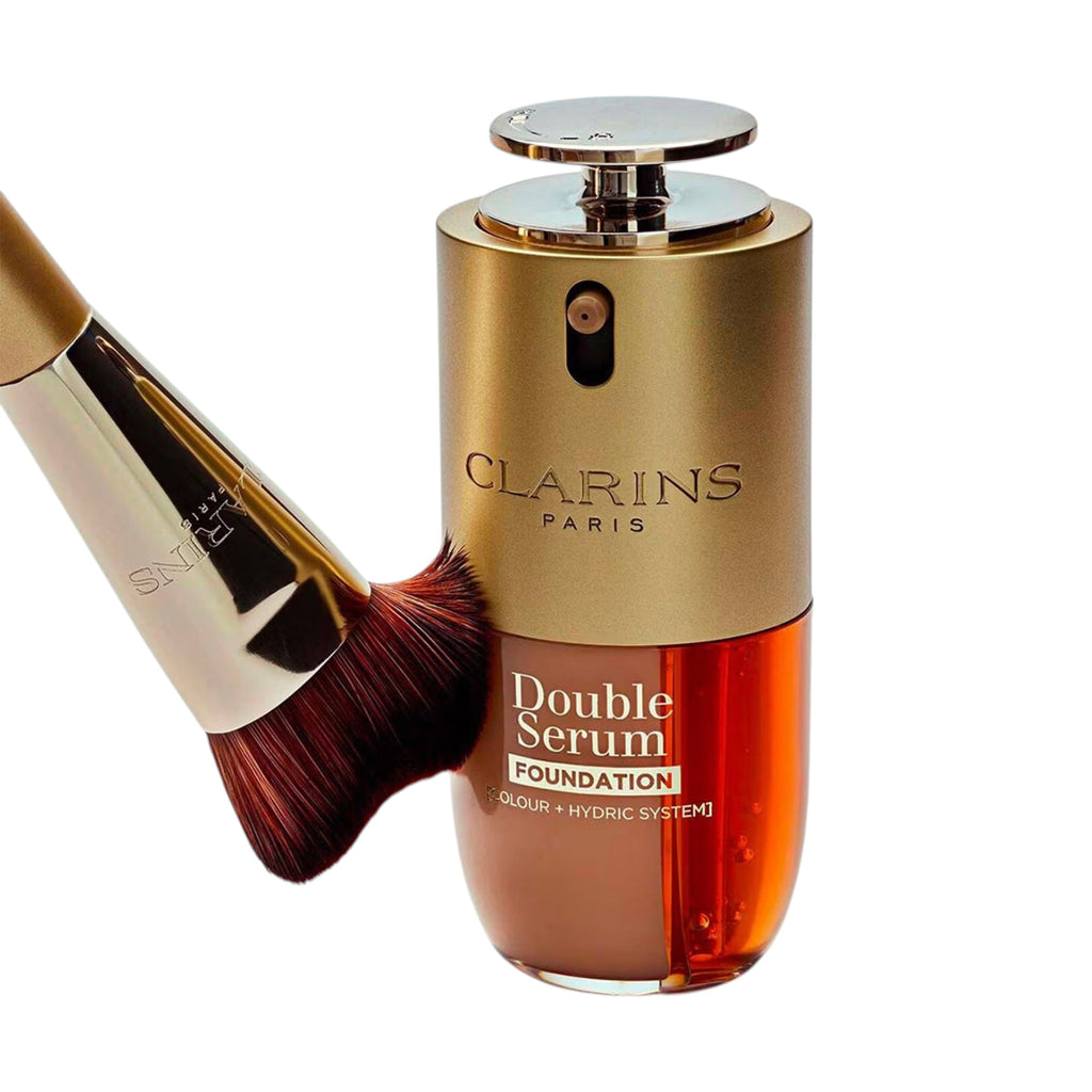 Clarins Double Serum Foundation bottle: gold-toned top, silver pump, clear amber bottom with brown foundation and orange seru