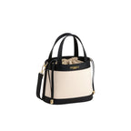 Light beige canvas bucket bag with black leather trim, top handles, shoulder strap. Drawstring closure, gold-toned hardware,