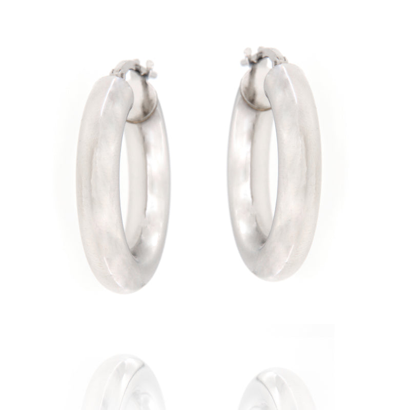 Pair of chunky, tubular silver-toned hoop earrings with a smooth, slightly matte finish and hinged post closures.