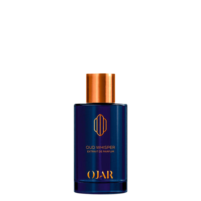 A luxury bottle of OJAR Oud Whisper Extrait de Parfum. The cylindrical bottle is crafted from deep, translucent midnight-blue glass and features the OJAR logo and fragrance name in a vibrant copper-orange foil. It is topped with a reflective copper-toned metallic cap, presented against a clean white background.