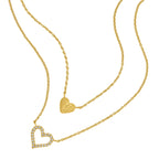 Gold-toned duochain necklace with two heart pendants, one solid with an engraved 'P' and one open heart with clear crystals.