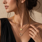 Gold-toned duochain necklace with two heart pendants: one solid with an engraved 'P', and one open heart outlined with clear