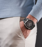 Large, angular gunmetal-toned watch with a black dial, three subdials, and a two-tone gunmetal and silver-toned metal bracele