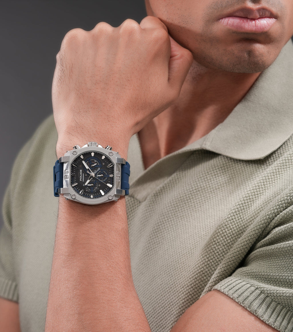 Silver-toned stainless steel watch with an angular case, black and blue chronograph dial, and a blue silicone strap.